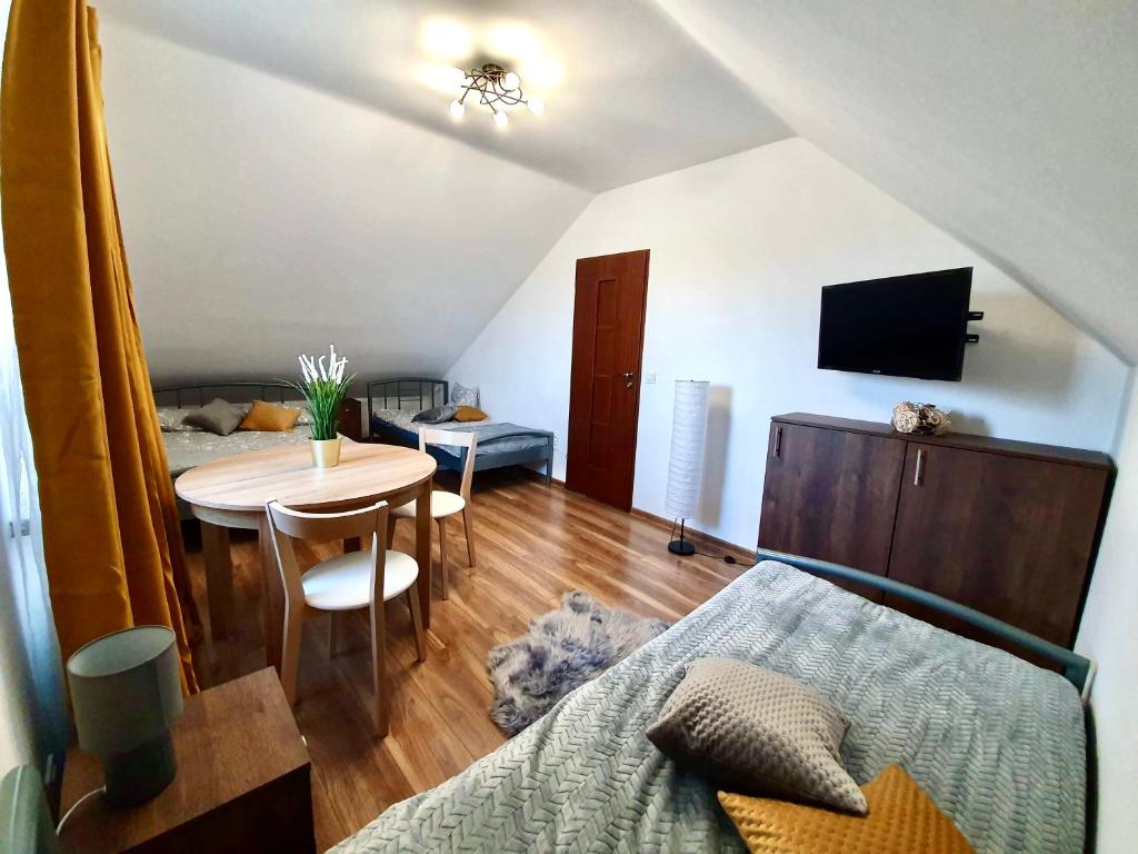 a room with a table and a bed and a bedroom at Dom Wczasowy u Marci in Tymień