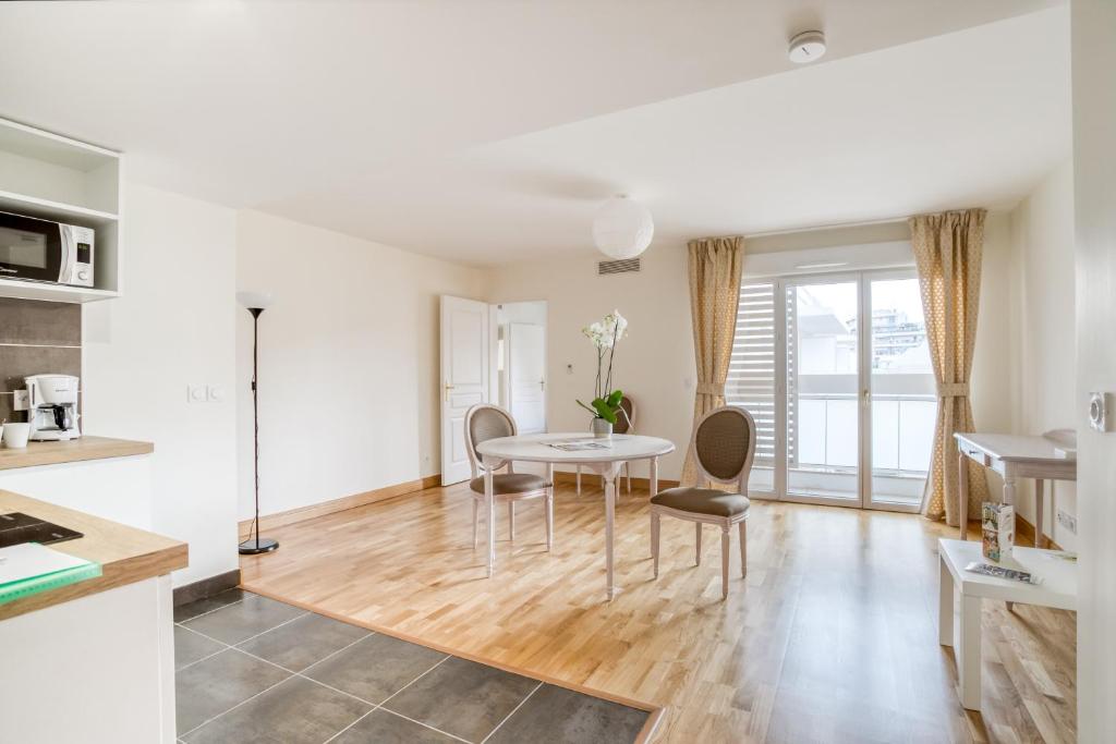 a kitchen and living room with a table and chairs at MEDICIS HOME Nice Saint -Laurent- Du -Var in Saint-Laurent-du-Var