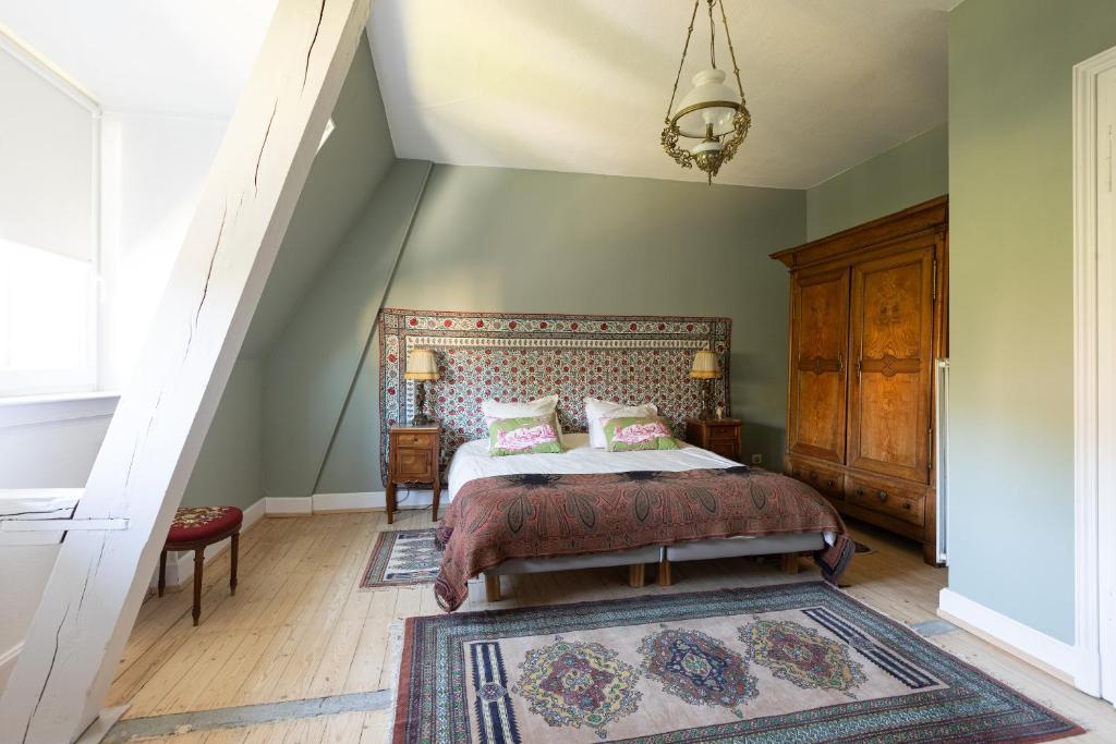 a bedroom with a large bed and a staircase at Appartement bourgeois Les Etoffes de Mulhouse in Mulhouse