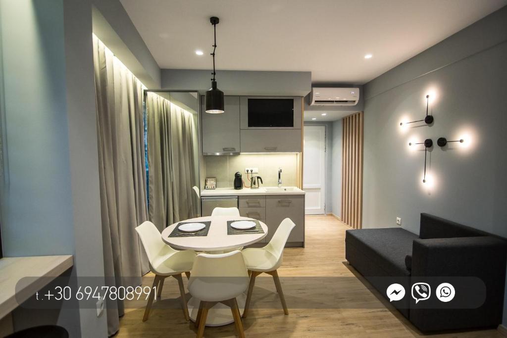 Il comprend une cuisine et un salon avec une table et des chaises. dans l'établissement Preveza Suite Stay Leoforos Irinis 84b, à Prévéza