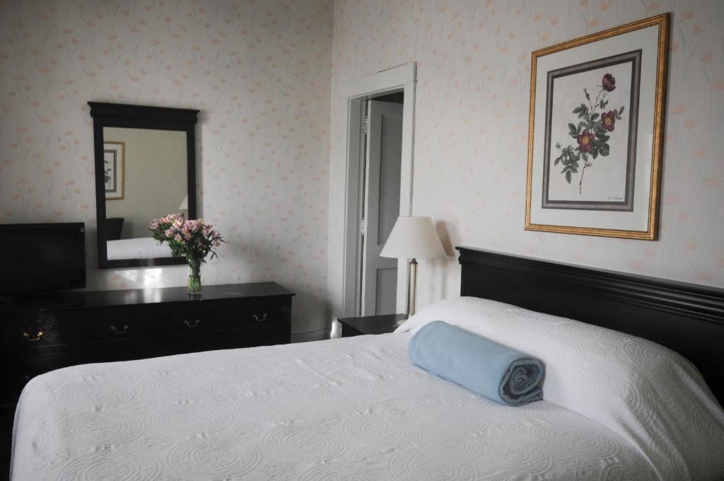 a bedroom with a bed with a blue pillow on it at Hotel Coolidge in White River Junction