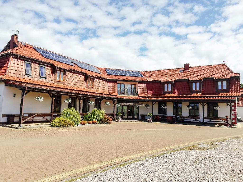 een groot gebouw met zonnepanelen op het dak bij Zajazd Dolina Sadosiów in Godkowo