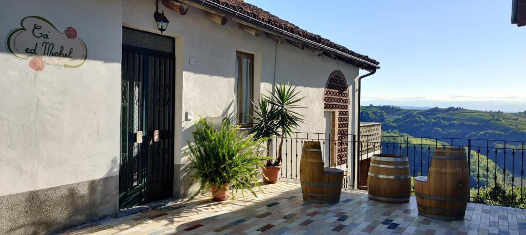 uma casa com uma varanda com um portão e vasos de plantas em Cà ed Michel em Neviglie