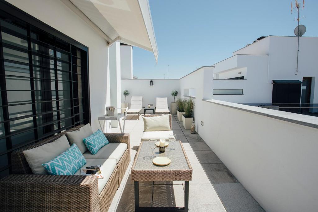 un patio con divano e tavolo sul balcone. di Attic with terrace- 1Bd 1Bth- Corral del Rey a Siviglia