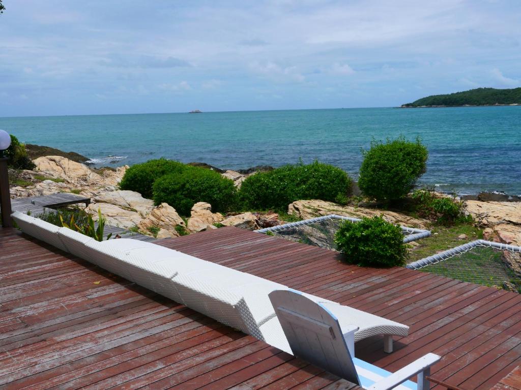 a white bench sitting on a wooden deck overlooking the ocean at Vimarn Samed Resort in Ko Samed