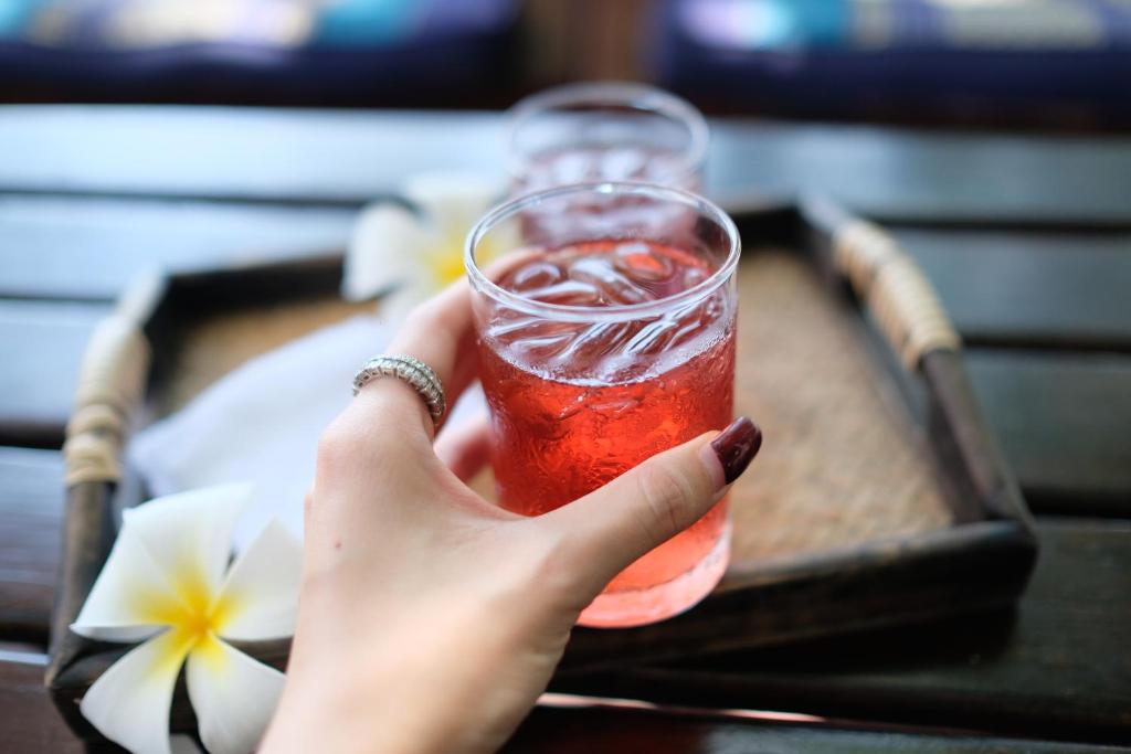 a person holding a drink in a glass at Vimarn Samed Resort in Ko Samed