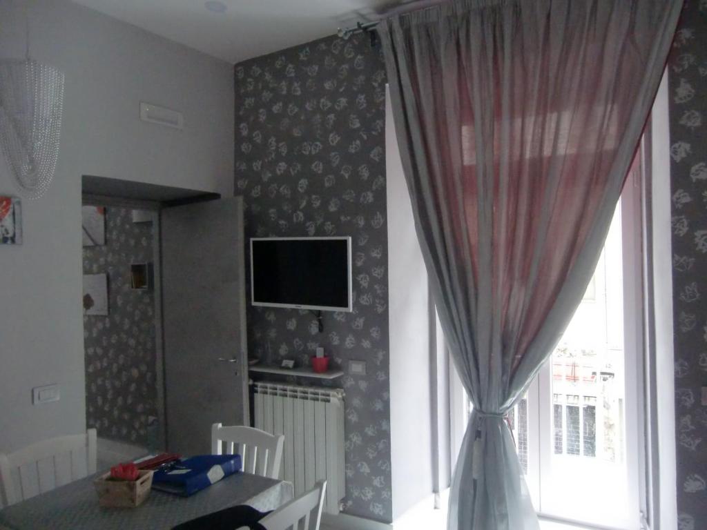 jadalnia ze stołem i telewizorem na ścianie w obiekcie Guesthouse Aaron2 w mieście Neapol