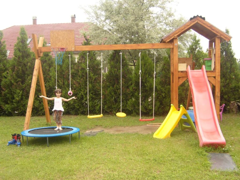 una chica parada en un trampolín en un patio de juegos en Béke Vendégház en Szada