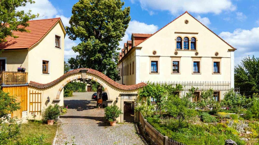 una casa grande con un arco delante de ella en Landhotel Gut Wildberg, en Meißen