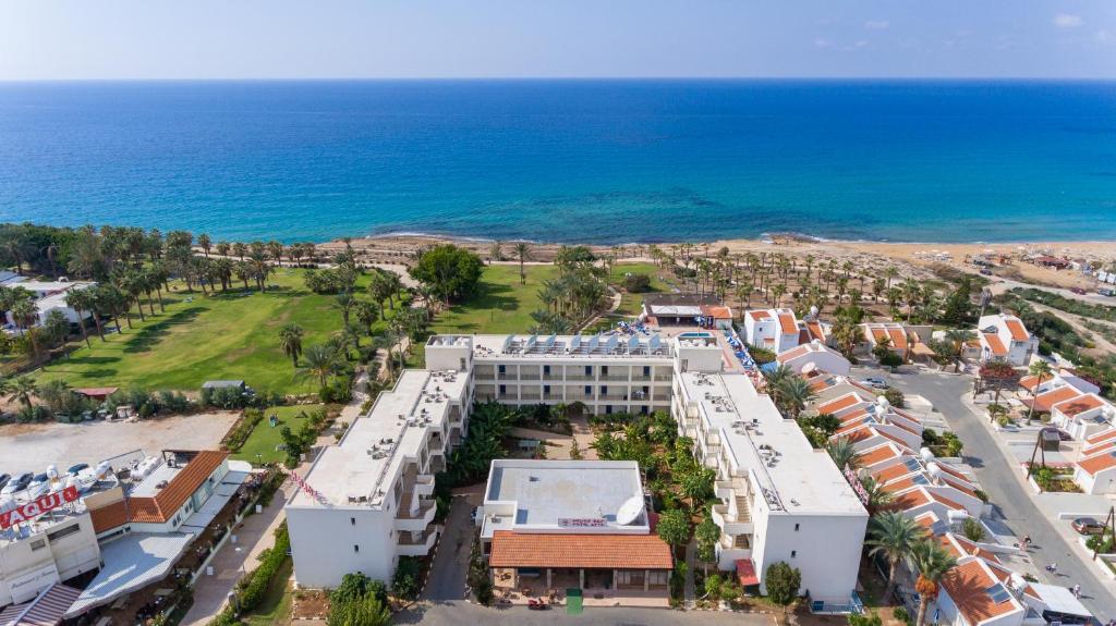 una vista aerea di un resort vicino all'oceano di Helios Bay Hotel and Suites a Paphos