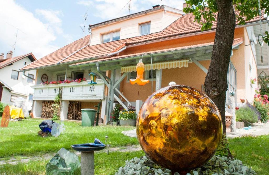 una casa con una gran pelota delante de un patio en Ferienwohnung Winterstetter Am Waldglasgarten, en Riedlhütte
