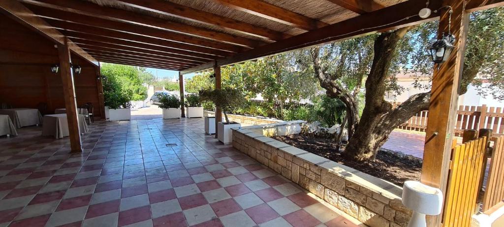 Una pasarela cubierta con un árbol en un edificio en Bed and Breakfast La Terrazza, en Cisternino