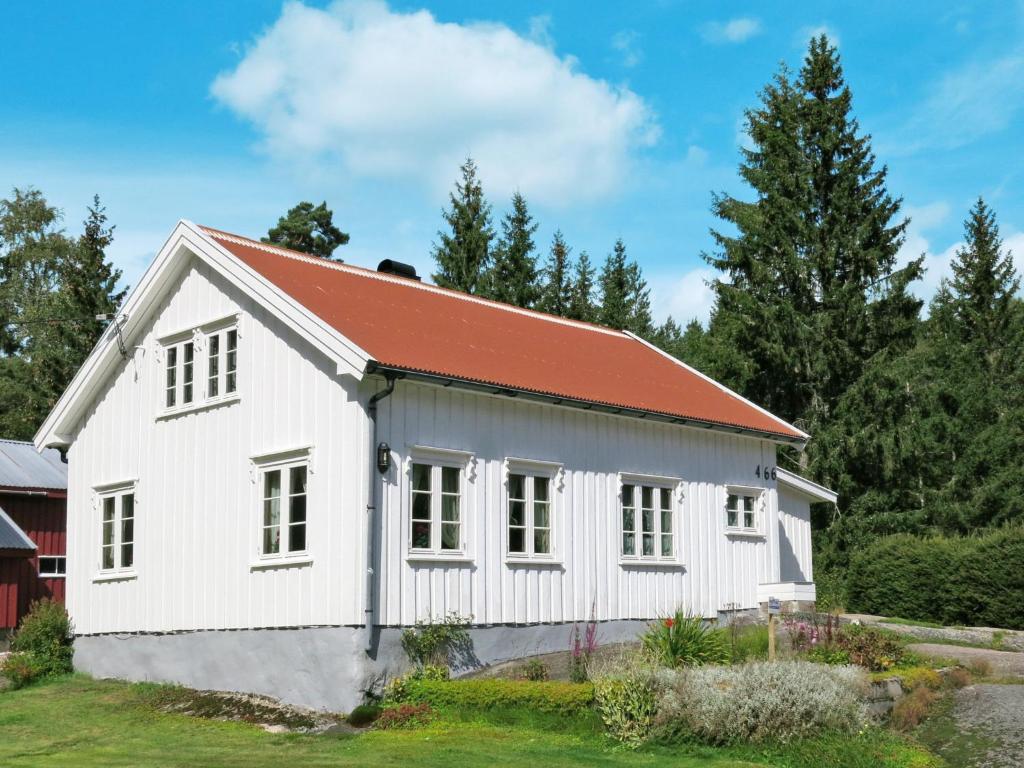 une maison blanche avec un toit rouge dans l'établissement Holiday Home Øygårdsheia - SOO615 by Interhome, à Grimstad