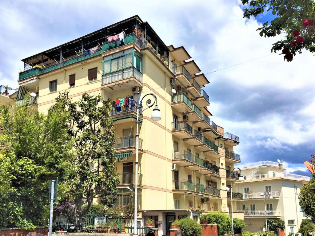 wysoki żółty budynek z zegarem w obiekcie Apartment Ritamar by Interhome w Sorrento