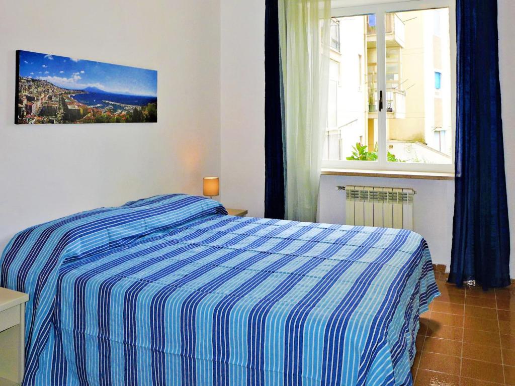 sypialnia z niebiesko-białym łóżkiem i oknem w obiekcie Apartment Ritamar by Interhome w Sorrento