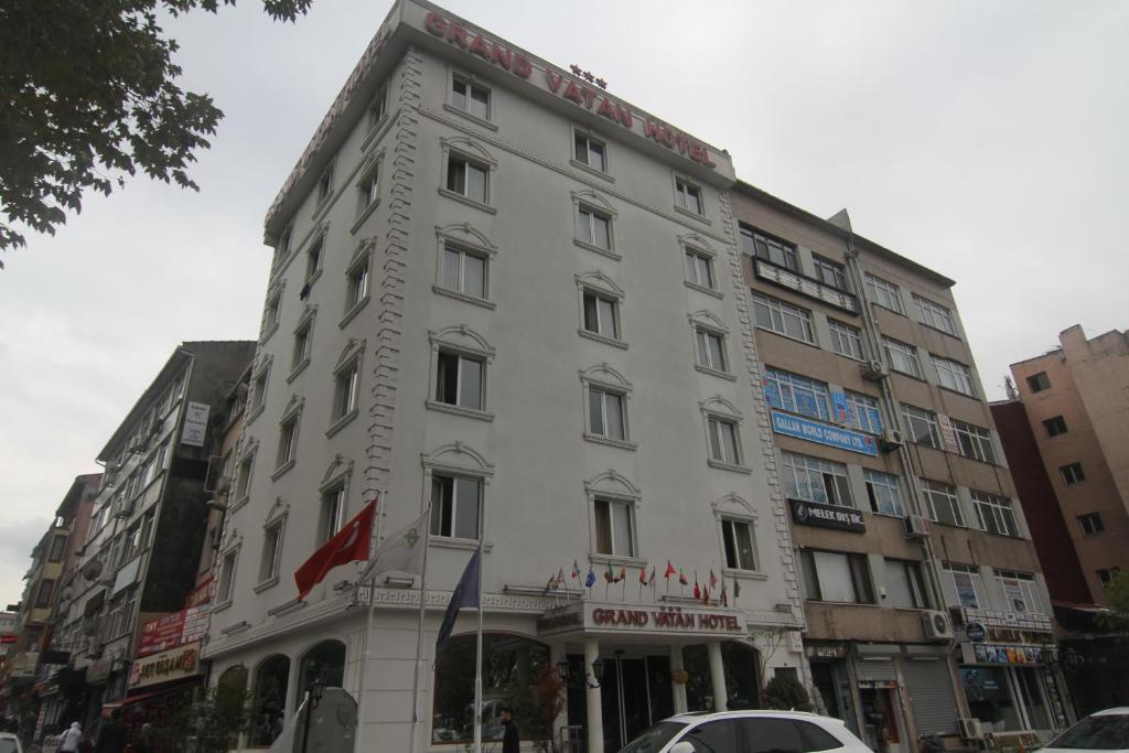 a white building on a city street with a car at GRAND VATAN HOTEL in Istanbul