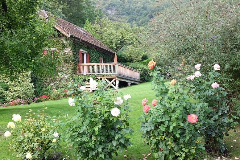 una casa con terraza y rosas en un patio en Ferienapartments Gutshof Brandis, en Lana