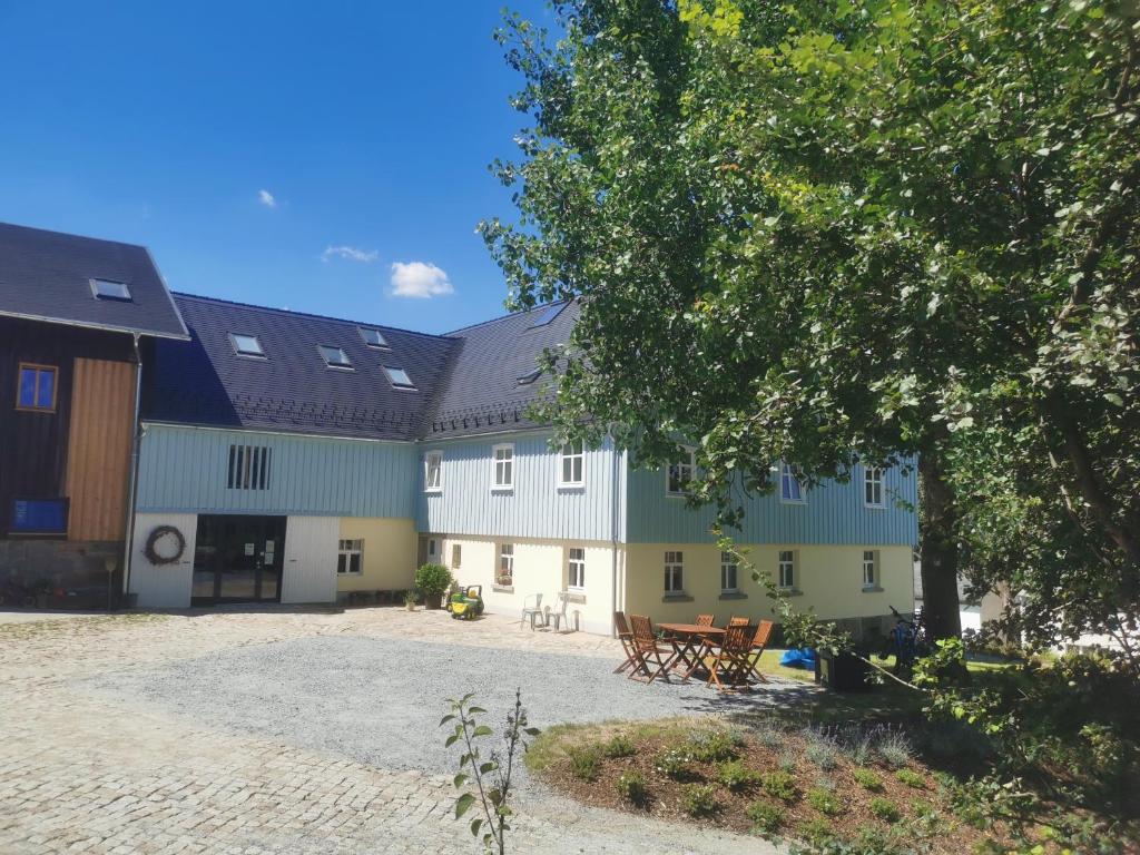 un gran edificio con un árbol delante en Gutshof Schirgiswalde, en Schirgiswalde