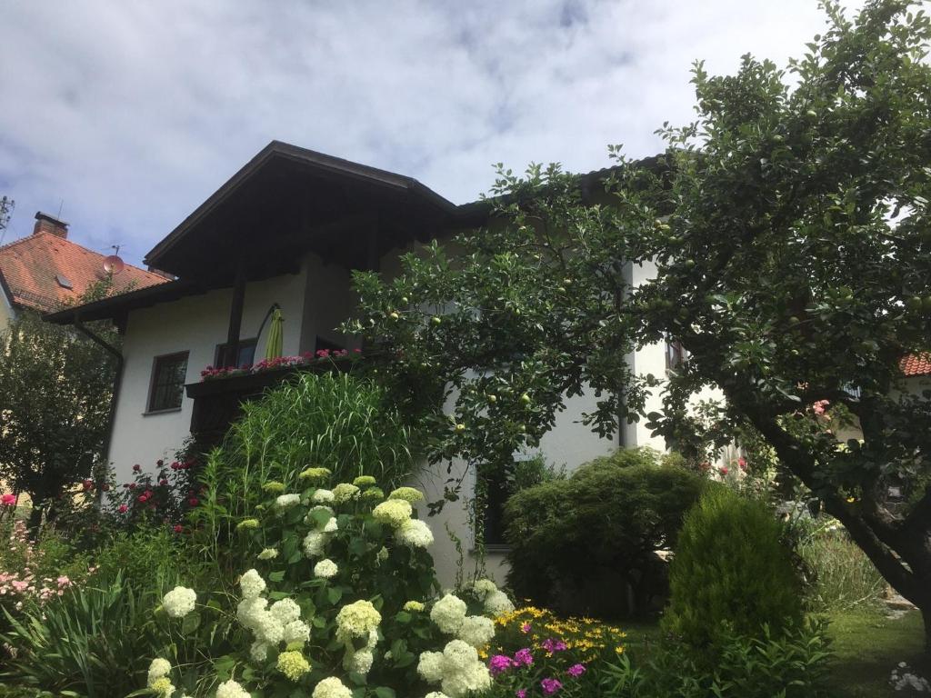 a white house with flowers in front of it at Ferienwohnung Evi in Auerbach