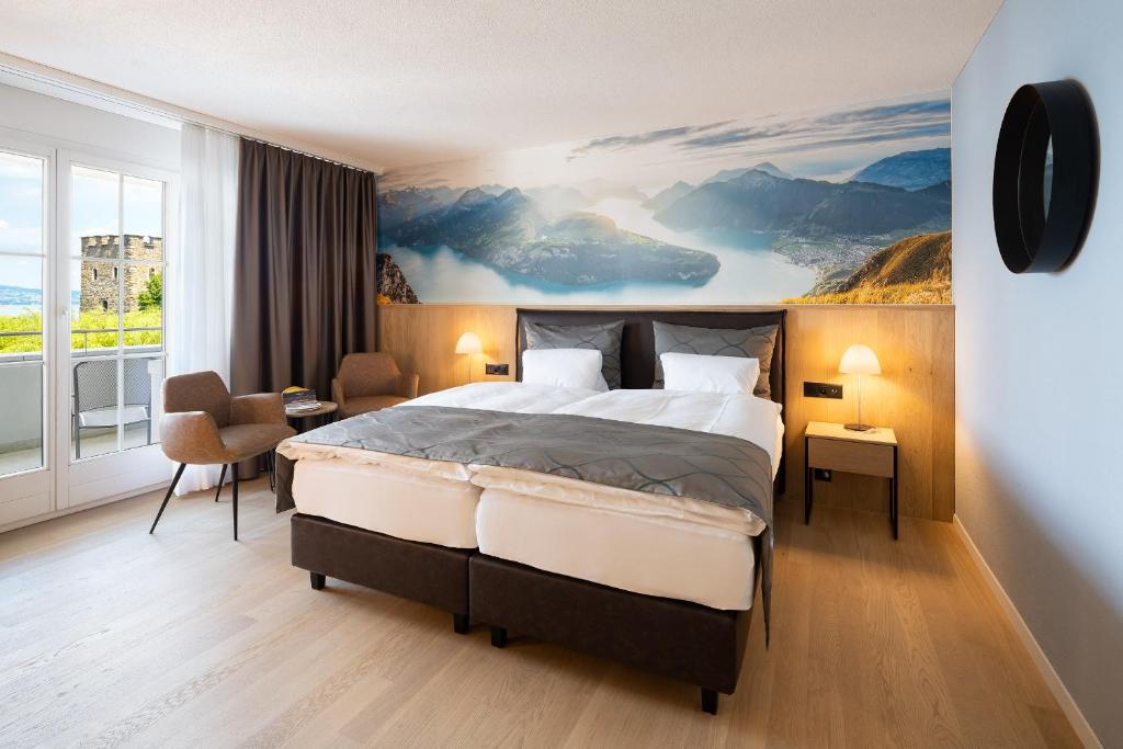 a bedroom with a bed and a painting on the wall at Hotel Winkelried am See in Stansstad
