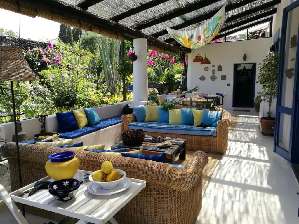 un patio con sofá, sillas y mesa en La Rosamarina, en Stromboli