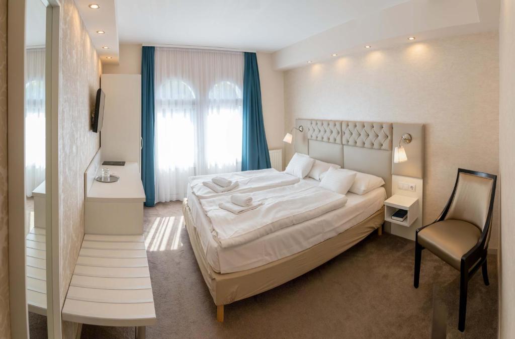 Кровать или кровати в номере Bástya Konferencia és Wellness Hotel
