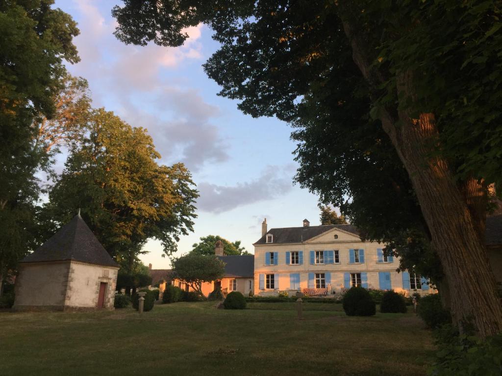 une grande maison blanche sur un champ herbeux dans l'établissement Château de Pintray, à Lussault-sur-Loire