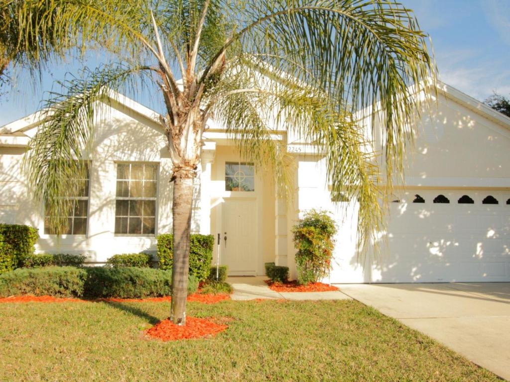 una palmera frente a una casa blanca en 4 Bed 2245, en Kissimmee