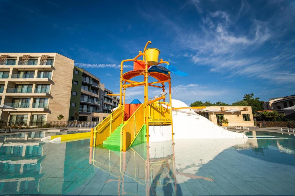 a colorful water slide in a swimming pool at HVD Reina del Mar - Premium Spa Service & Free Parking in Obzor