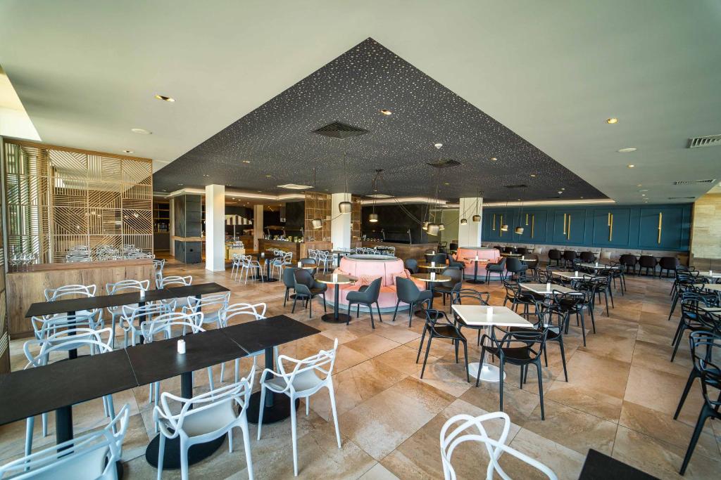 a dining room with tables and chairs and a restaurant at HVD Reina del Mar - Premium Spa Service & Free Parking in Obzor