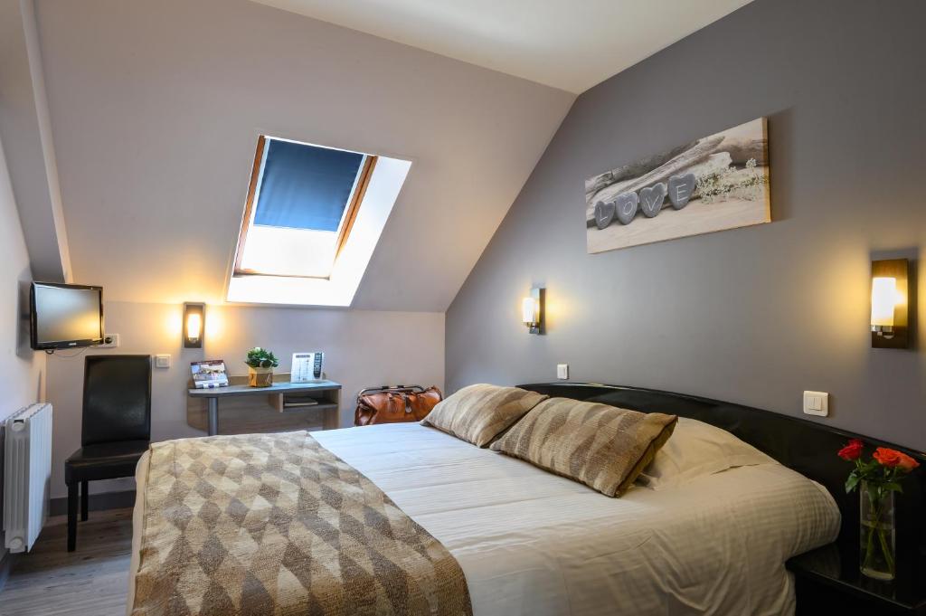 Postel nebo postele na pokoji v ubytování Hôtel Le Bayeux