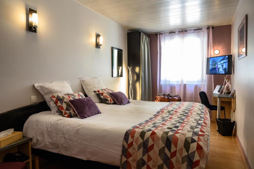 Postel nebo postele na pokoji v ubytování Hôtel Le Bayeux