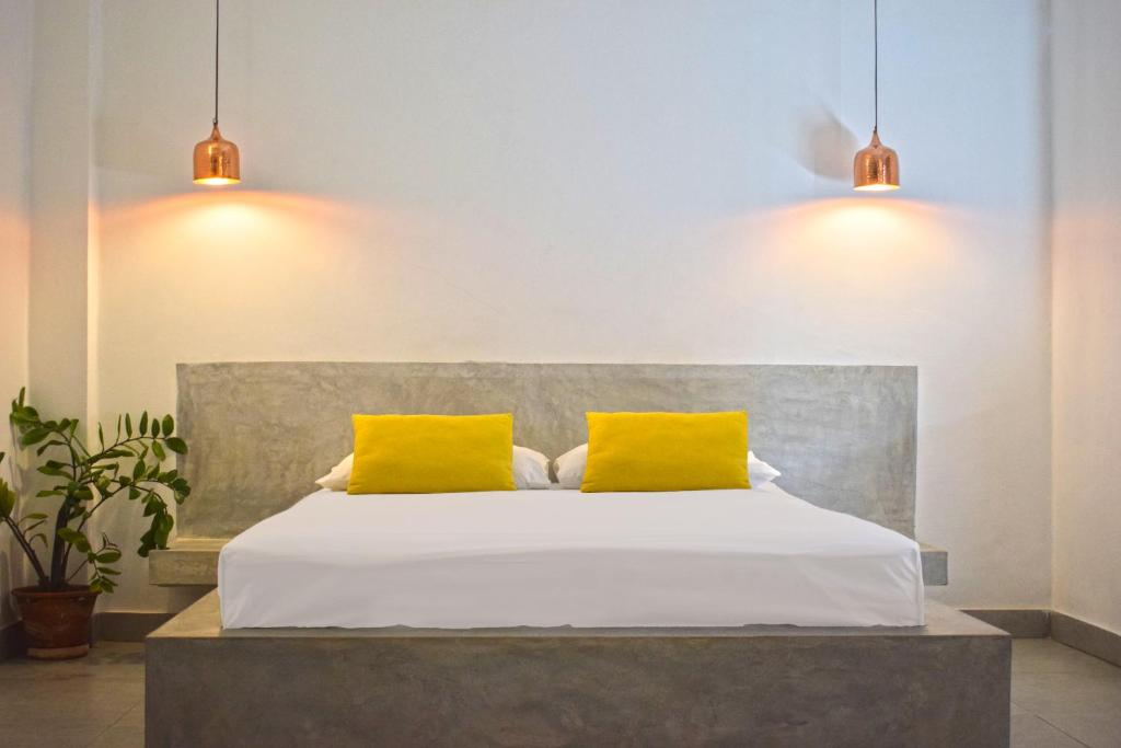 - une chambre avec un lit et 2 oreillers jaunes dans l'établissement City Beds Colombo, à Colombo