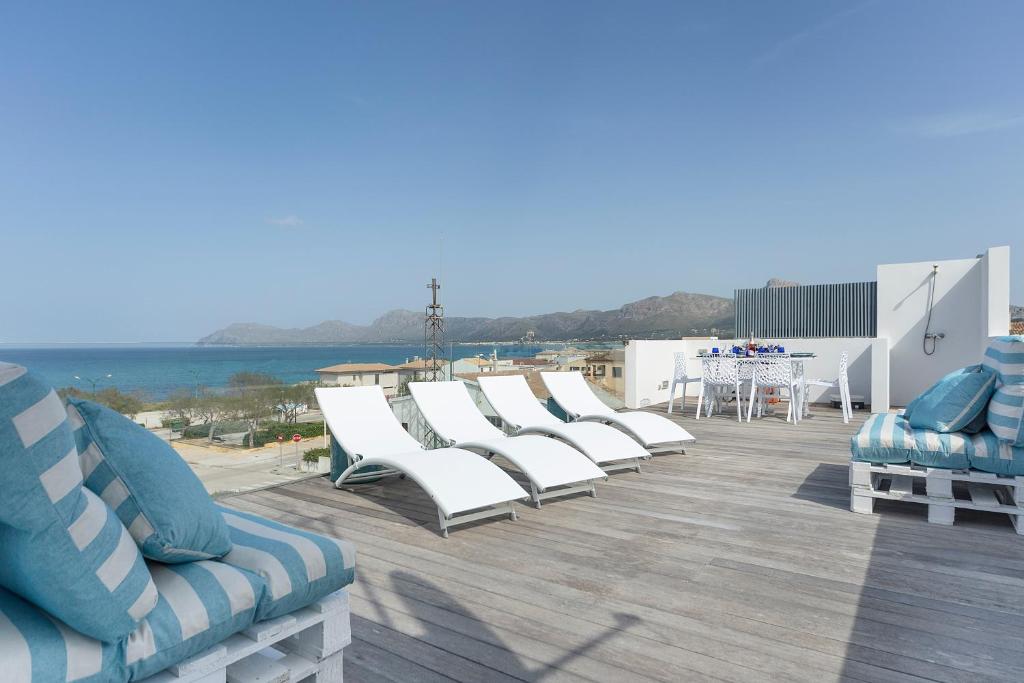 una fila de sillas blancas sentadas en la azotea en View House with terrace Son Serra Mallorca, en Son Serra de Marina