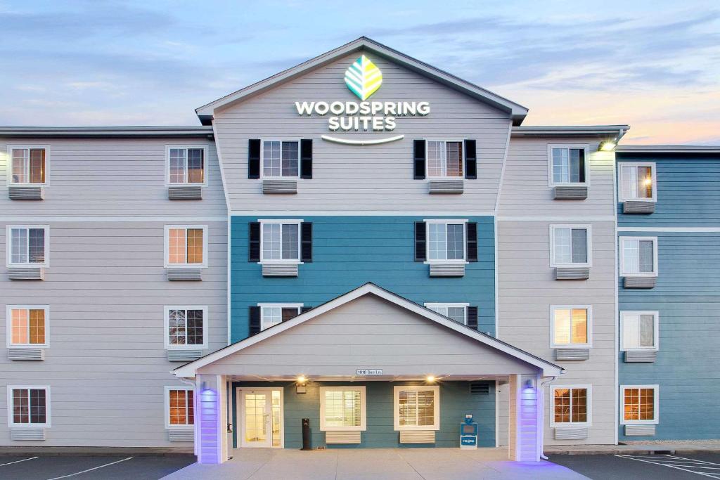 un bâtiment avec un panneau indiquant des suites en bois dans l'établissement WoodSpring Suites Charlotte Shelby, à Shelby