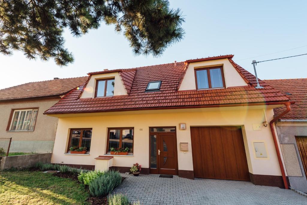 Kovalovice的住宿－Apartmán Pod borovicí，一座红色屋顶的房子和一个车库