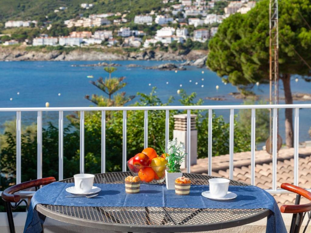 a table with a blue table cloth and fruit on a balcony at Holiday Home El Morer by Interhome in Llança