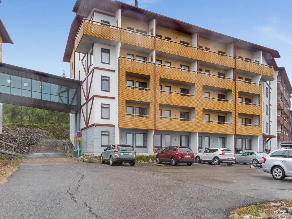 ein großes Gebäude mit auf einem Parkplatz abgestellten Autos in der Unterkunft Holiday Home Ylläs chalets 2207 by Interhome in Ylläsjärvi