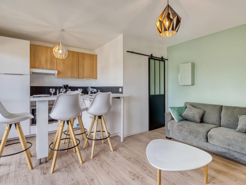 uma cozinha e sala de estar com sofá e cadeiras em Apartment Neptune by Interhome em Cabourg