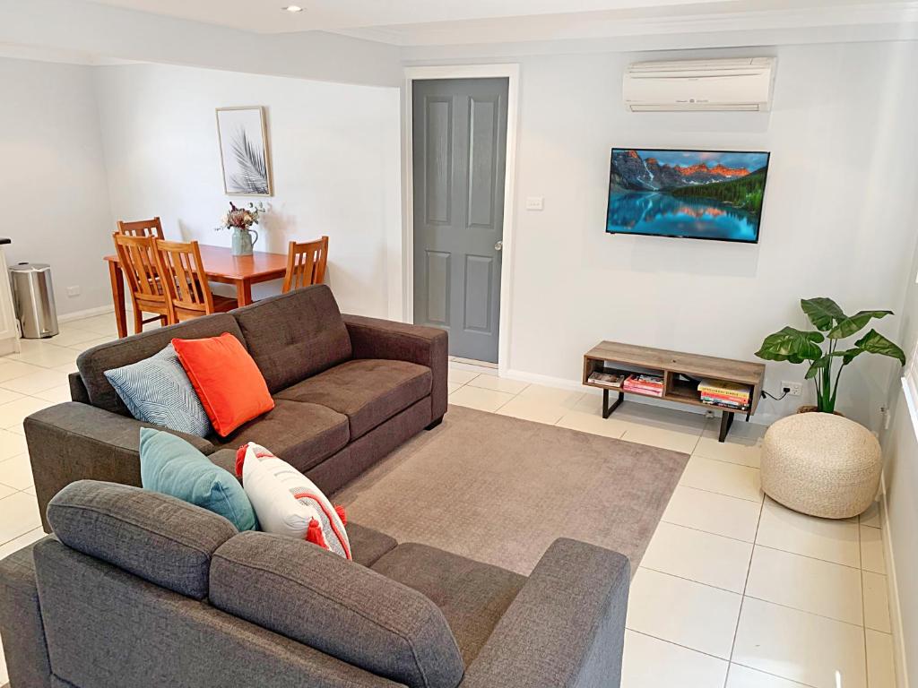 a living room with a couch and a table at City Center - Comfortable 2-Bedroom Apartment in Armidale