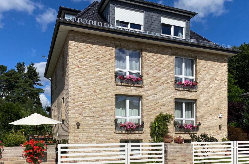 a brick house with windows and a white fence at Green Caroline in Berlin