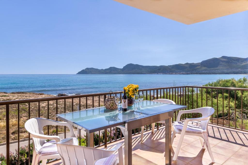 ソン・セッラ・デ・マリーナにあるSon Serra Beach front line Houseの海を望むバルコニー(青いテーブル、椅子付)