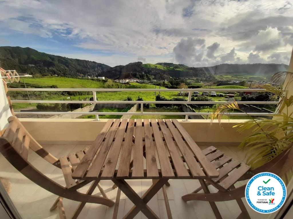 una panca di legno seduta in cima a un balcone di The Furnas Azores House a Furnas