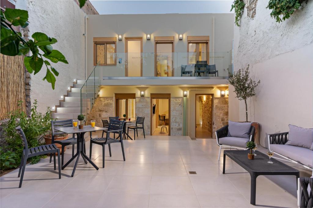 eine Terrasse mit Tischen und Stühlen in einem Gebäude in der Unterkunft Erotokritos City Luxury Suites in Rethymno