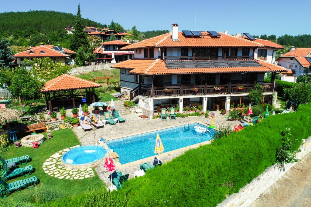 uma casa com piscina em frente a uma casa em Guest House Brezata - Betula em Glavatartsi