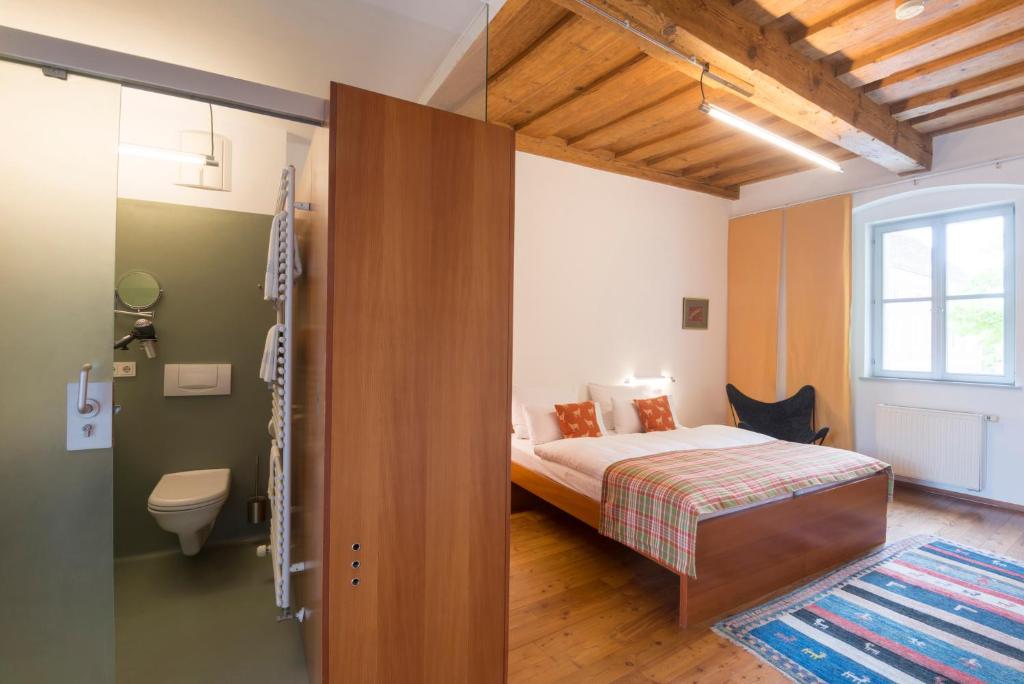 a small bedroom with a bed and a bathroom at Der Ederer in Weiz
