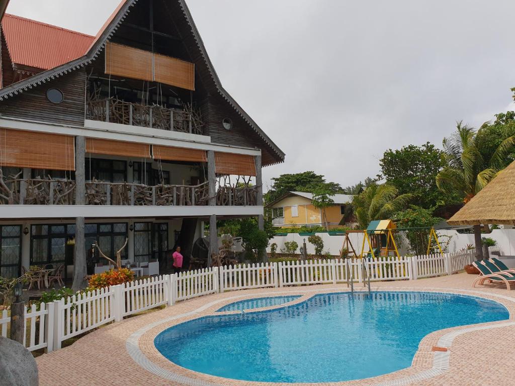 a resort with a swimming pool in front of a building at La Digue Emerald Villa in La Digue