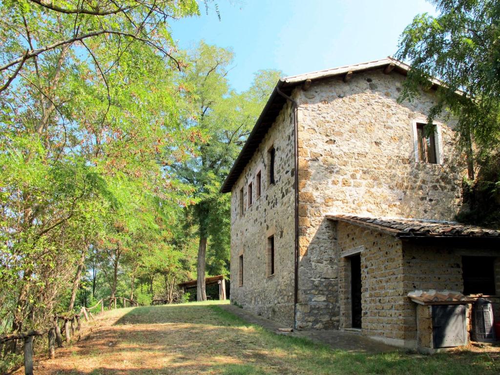 an old stone building with trees in the background at Holiday Home Topano by Interhome in Pianucciole