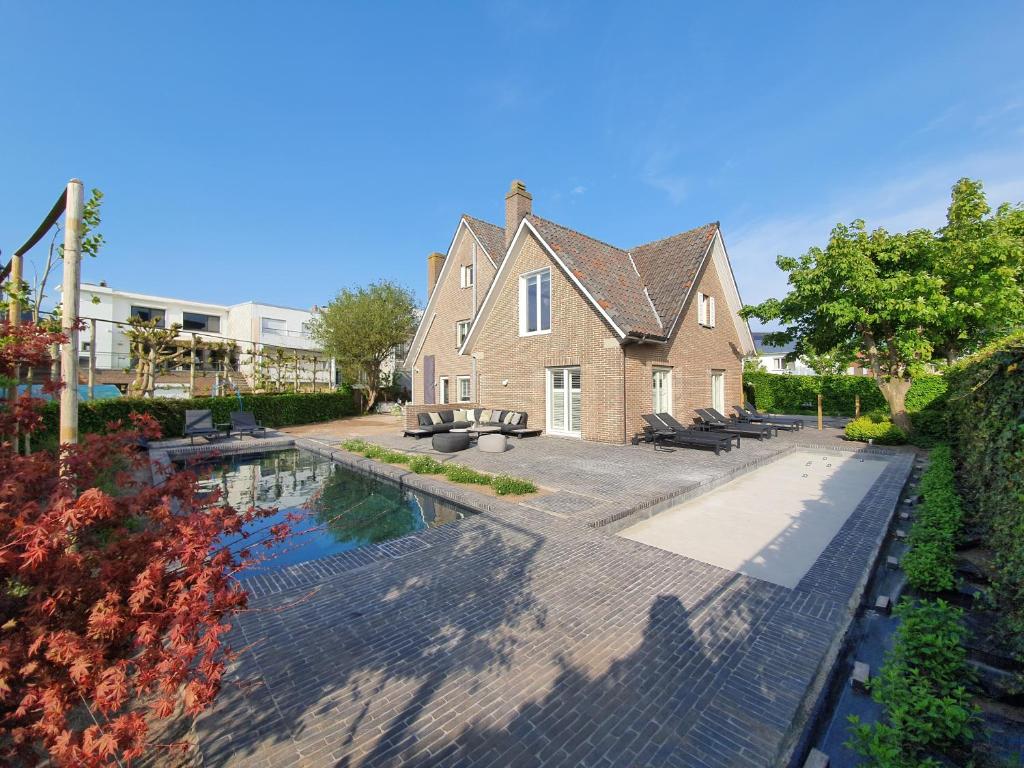 a house with a swimming pool in front of a house at B&B Vis-à-Vis in Wenduine