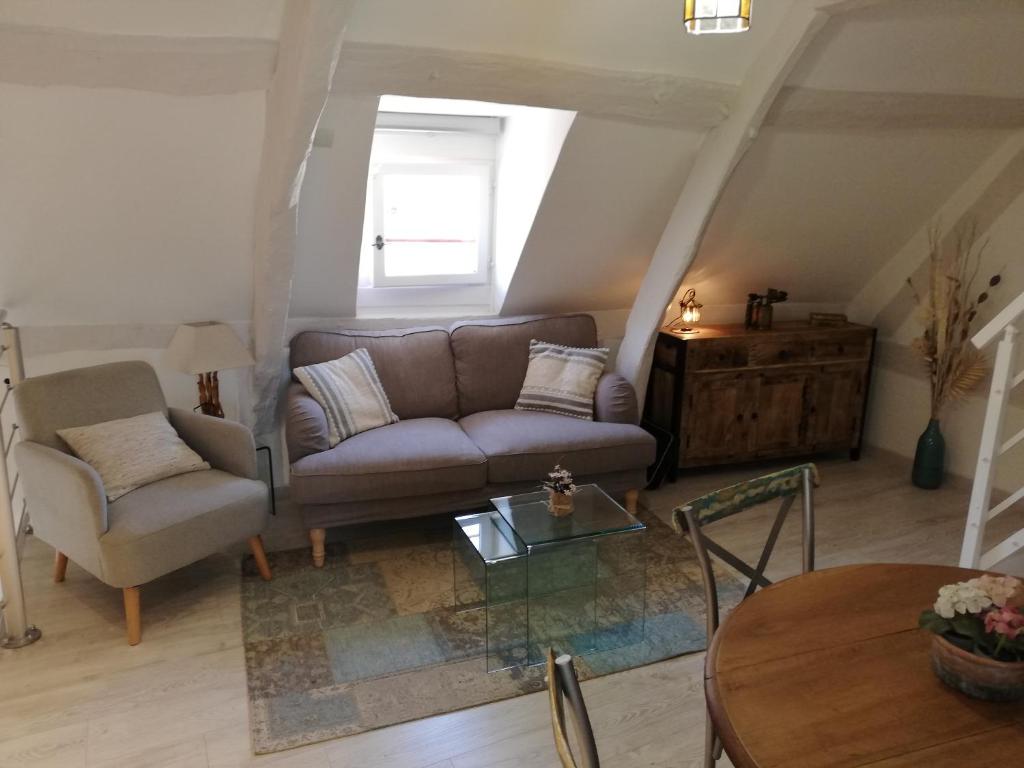 ein Wohnzimmer mit einem Sofa und einem Tisch in der Unterkunft Honfleur-loft in Honfleur